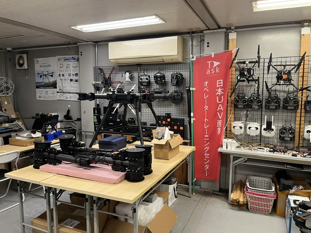 自社開発の機体と送信機が並ぶTask drone Labの工房